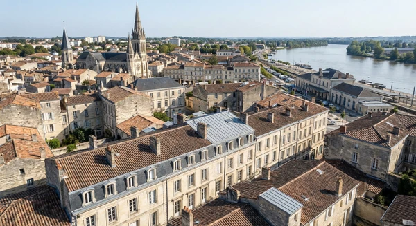 Une vue aérienne ou perspective de la ville de Libourne montrant son tissu urbain avec bâtiments résidentiels et patrimoniaux caractéristiques, ou une image de la gare de Libourne avec ses abords urbains, illustrant ainsi le territoire d'intervention de l'entreprise en Gironde