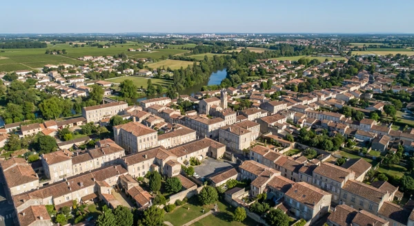 Vue aérienne ou perspective urbaine de Saint-Loubès en Gironde montrant le tissu urbain avec bâtiments résidentiels et structures architecturales caractéristiques de la région, illustrant le territoire d'intervention de l'entreprise de couverture.