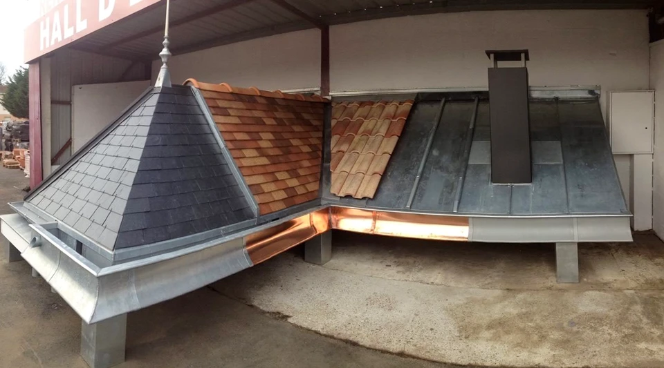 Chantier de réfection de toiture en cours, ouvriers installant une structure de ventilation ou cheminée sur toit résidentiel