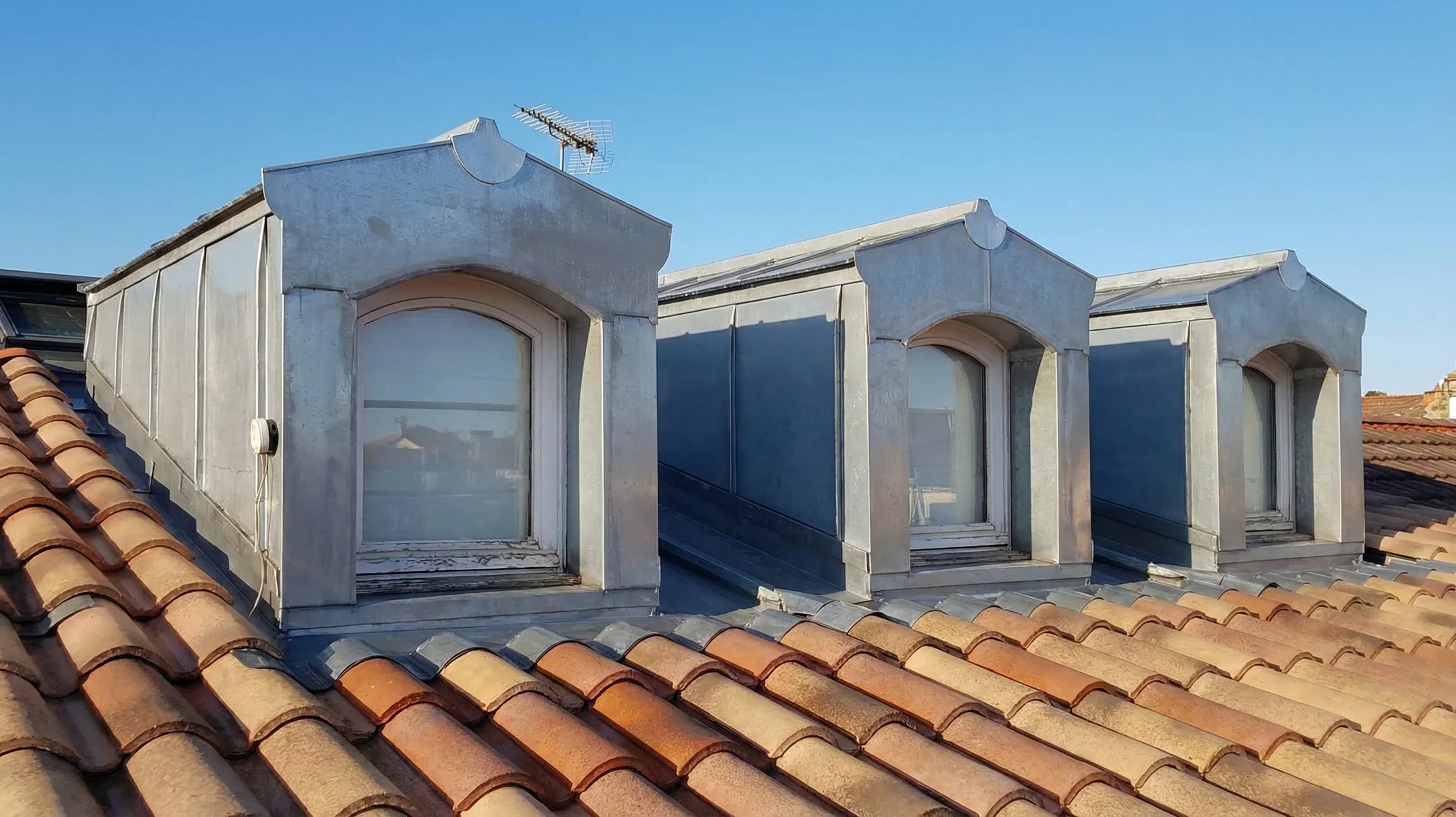 Extérieur d'une maison avec toiture en tuiles canal terre cuite et système d'évacuation des eaux pluviales